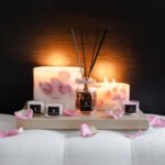 Velvet Rose - 200ml Fragranced Octagonal Diffuser with botanical candles and mini travel candles on a tray on a bed side