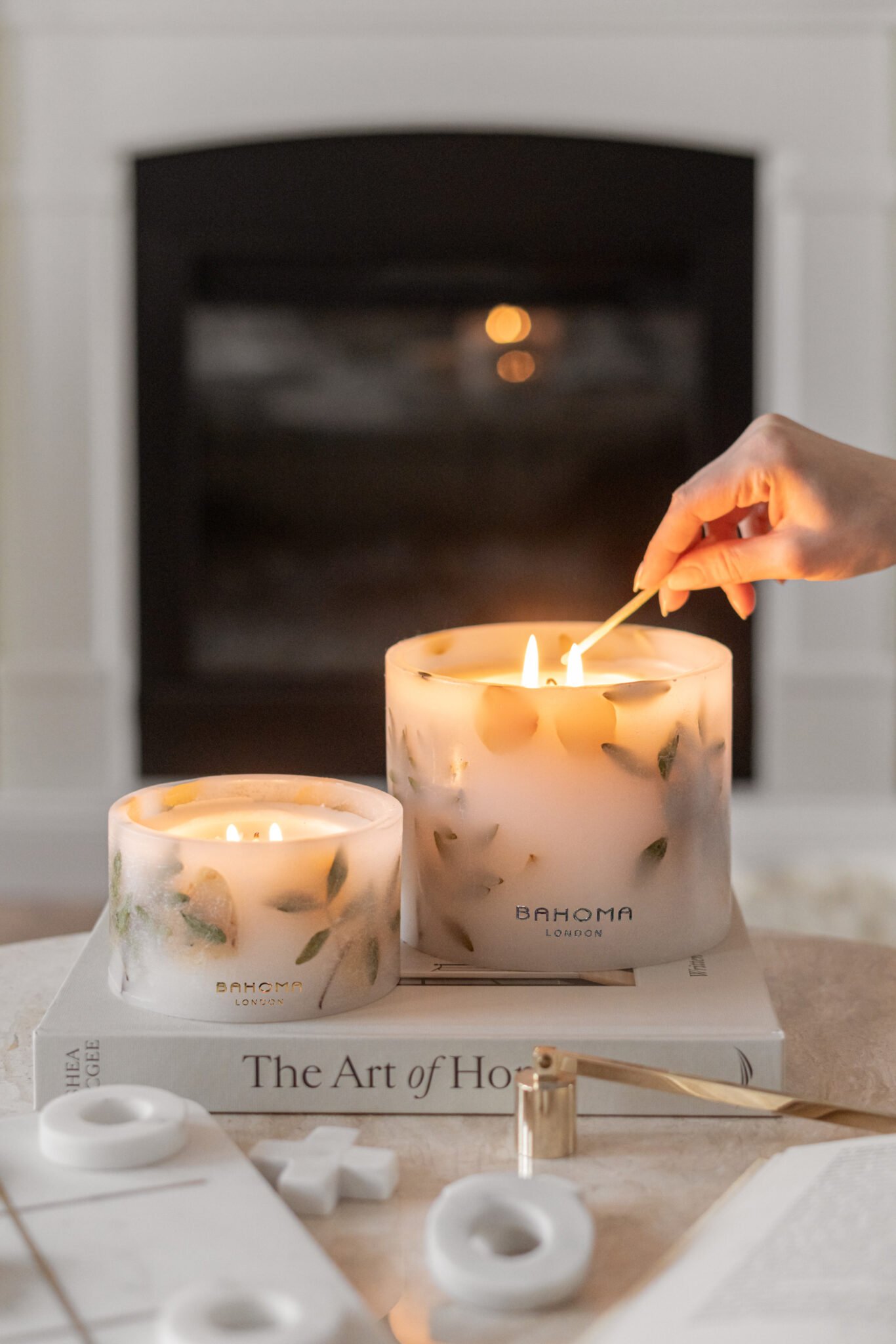 Close up of the Amalfi Coast Scented Grand Pillar Candle highlighting its large scale and clean white wax. A hand visible lighting up the candle.