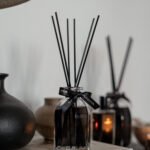 Bahoma Obsidian Collection 100ml fragranced octagonal diffuser with black liquid and black reeds styled on books in a modern interior