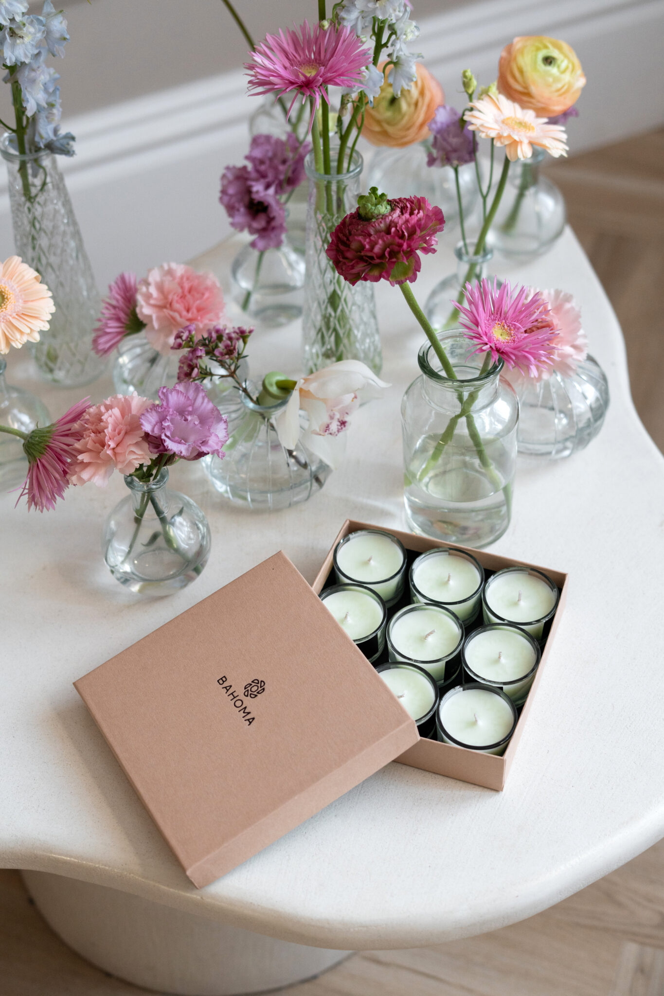 Primrose & Amberwood – Nine Lights Candle Set | Alchemy Collection. Lifestyle image showing open box containing nine mini candles in pastel green colour.